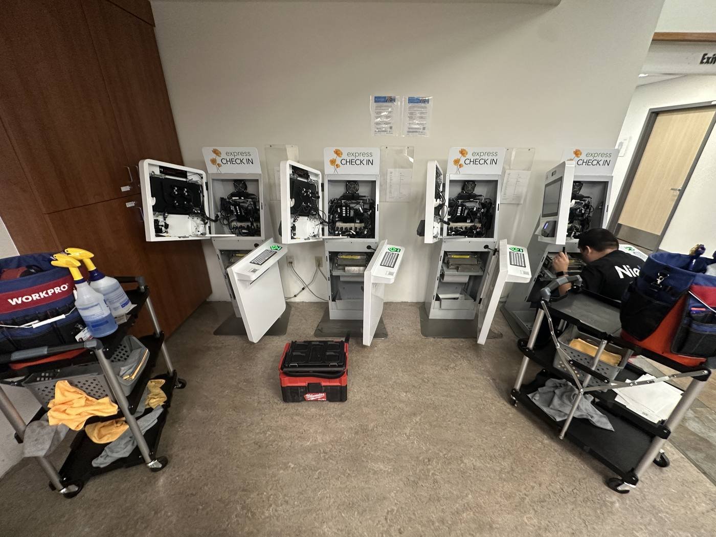 Nieko Technology technician servicing a bank of patient check-in kiosks